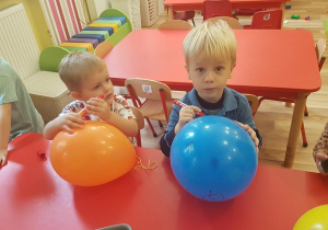 Chłopcy malują balony.